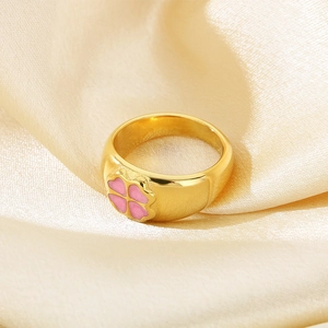 Detail of 10mm wide gold ring featuring pink clover petals on silk background