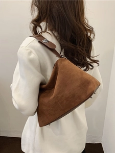 Sac à bandoulière rétro en daim marron foncé pour femme, porté par un mannequin stylé