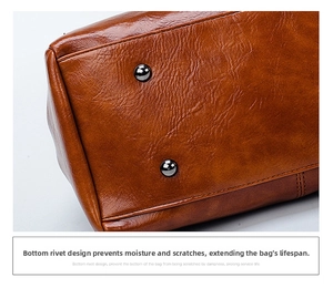 Detail view of brown oil wax leather bag bottom featuring protective metal rivets