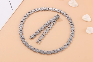 Dettaglio set di gioielli per magnetoterapia in acciaio al titanio argento con maglie XO