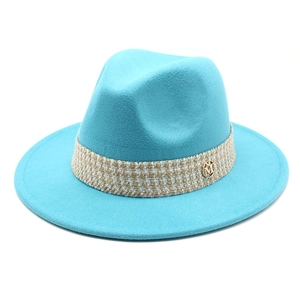 Detailed close-up of blue wool fedora with tweed band and golden M-letter buckle