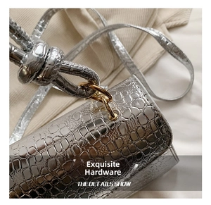 Close-up of metallic silver crocodile pattern handbag with golden metal hardware detail