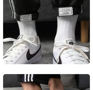 Détail de chaussettes en coton blanc avec baskets en cuir et pantalon de sport rayé