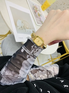 Primo piano di un orologio da donna dorato rettangolare con cinturino a catena