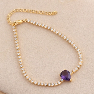 Detail of gold bracelet featuring purple teardrop zircon and adjustable lobster clasp