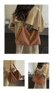 Detailed view of brown suede hobo bag shown handheld and worn on the shoulder by a model
