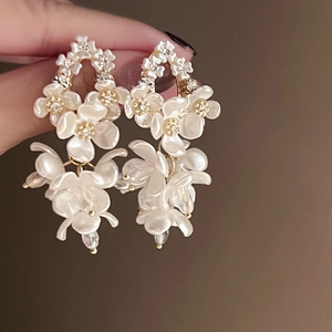 Detail of shell flower drop earrings with sparkling rhinestones and golden metal base