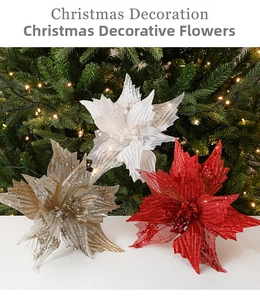 Close-up of glittery red and gold poinsettia flowers on a Christmas tree with warm lights
