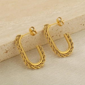 Elegant gold twisted square hoop earrings in stainless steel on a beige stone pedestal