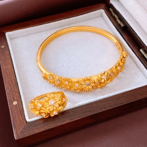 Detail of vintage gold flower jewelry set featuring floral relief and zircon inlay