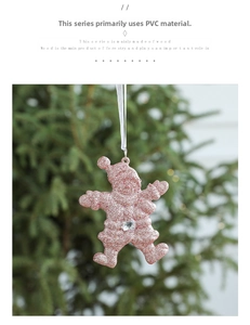 Pink glitter Santa Claus ornament with acrylic gemstone hanging on a green Christmas tree