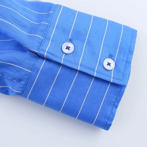 Close-up of blue striped cotton shirt cuff featuring double white round button closures