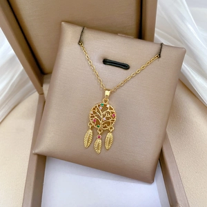 Close-up of golden dreamcatcher necklace with colorful zircons and feather charms