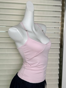 Dettaglio del top aderente rosa su manichino che mostra il tessuto morbido elastico