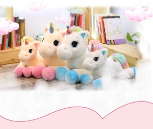 Detailed set of rainbow unicorn plush toys in multiple sizes on a wooden floor