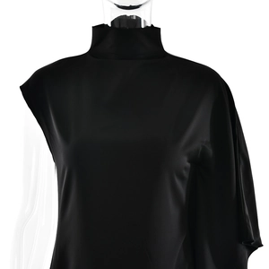 Détail de la robe noire élégante à col haut avec manche asymétrique et texture en soie