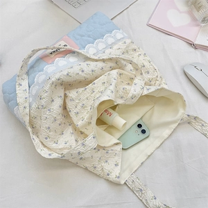 Detail of floral quilted tote bag interior showing storage for phone and cosmetics