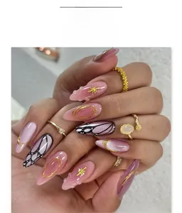 Close-up of butterfly wing pattern nails with pink gradient and gold star accents