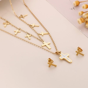 Detailed view of triple-layer gold necklace with cross pendants and matching stud earrings