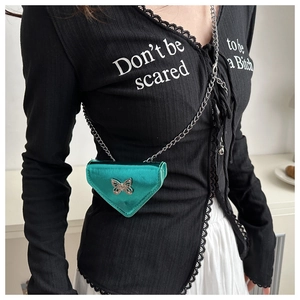 Détail du sac bandoulière triangle vert citron avec papillon argenté et chaîne