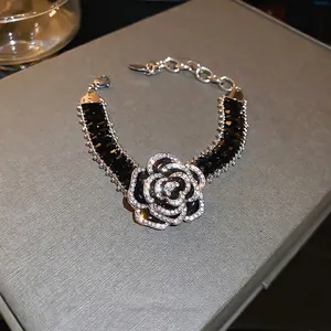 Luxurious black camellia flower bracelet with sparkling crystals and silver accents