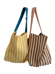 Minimalist striped knit tote bags with colorful pleated handles in a bohemian casual style