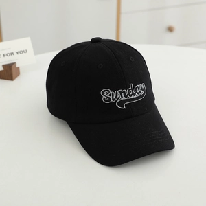 Close-up of white Sunday embroidery on black cotton baseball cap with curved brim detail