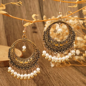 Bohemian retro hollow carved tassel earrings with white beads on a wooden branch