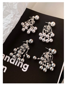 Macro view of French vintage pearl fringe earrings with silver chain tassel details