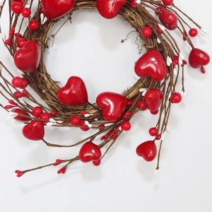 Detail of heart-shaped Valentines wreath with red berries and natural vine branches