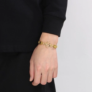 Close-up of a gold double-row Cuban chain bracelet featuring a marine anchor link for men
