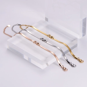 Detail of infinity charm snake chain bracelets in gold, silver, and rose gold finishes