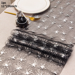 Close-up of black mesh Halloween table runner with silver spider web patterns and 3D spiders