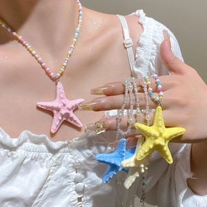 Colorful starfish pendants on beaded necklaces in pink blue yellow and white