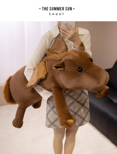Macro detail of large brown plush pegasus with golden wings and soft velvet texture