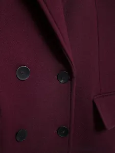 Détail de la texture en laine sergé bordeaux et des boutons noirs classiques à double boutonnage