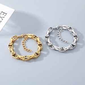 Gros plan de bracelets à maillons épais or et argent avec fermoir mousqueton et extension