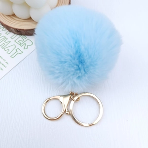 Close-up of sky blue faux fur pompom keychain with a gold lobster clasp and ring