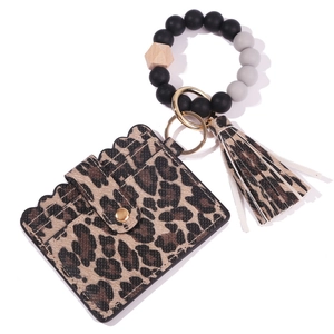Detail of leopard print card holder with silicone bead bracelet and PU tassel keychain