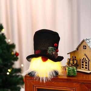 Close-up of glowing black hat Christmas gnome with pine cone on a warm wooden surface