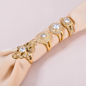 Elegant gold plated stainless steel rings with zircon stones on champagne silk fabric