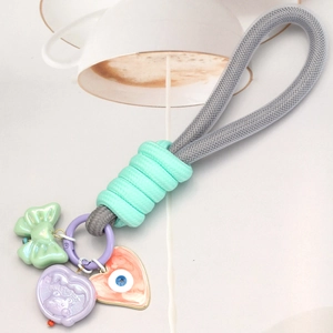 Détail du porte-clés tressé avec pendentif œil bleu et breloque cœur sur l'anneau