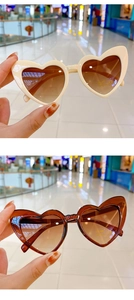 Detail showing cream and red heart-shaped sunglasses with UV400 and CE protection