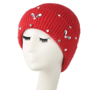 Close-up of red knit beanie with handcrafted pearls and butterfly crystal decorations