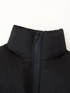 Close-up of the stand collar and matte zipper detail on a black padded jacket