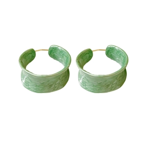 French vintage green resin hoop earrings with textured gold posts on white background