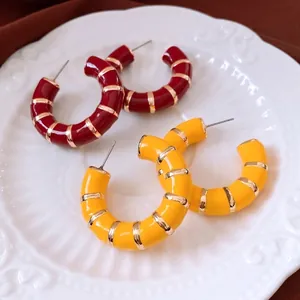 Elegant C-shaped hoop earrings in red and yellow enamel with gold stripe accents