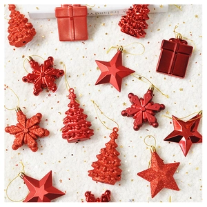 Flat lay of red Christmas ornaments in star, snowflake, and tree shapes on white fur