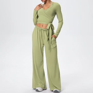 Détail d'un ensemble de yoga vert sauge avec haut cache-cœur et pantalon à cordon