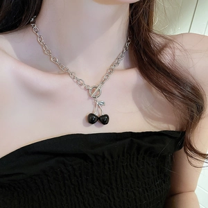 Close-up of silver OT buckle necklace with black cherry pendant on female model